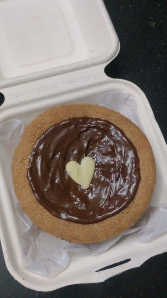 Mini cookie cake topped with chocolate and a white chocolate heart